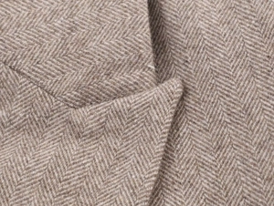 Macro shot of high-quality herringbone weave fabric in beige and brown wool blend