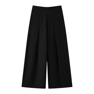 Detail of high-waist black wide-leg trousers with elegant pleats and smooth fabric texture