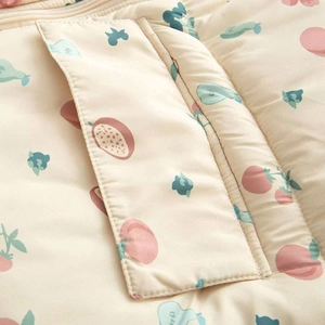 Détail d'une veste d'hiver pour bébé avec imprimés fruits et poche bien cousue