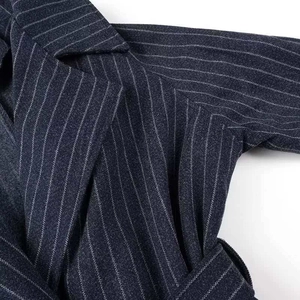 Gros plan détaillé du manteau marine à fines rayures avec revers et coutures précises