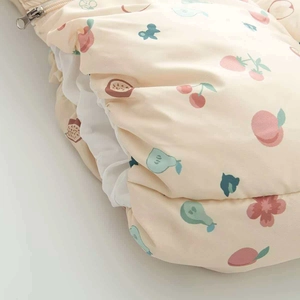 Détail de la gigoteuse matelassée pour bébé avec imprimés fruits et fermeture éclair métal