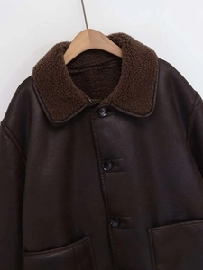 Détail de veste d'hiver en simili cuir marron avec col en peau de mouton et boutons