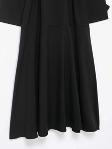 Detail eines klassischen schwarzen zweireihigen Trenchcoats mit Saum und Stoffstruktur