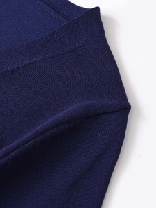 Détail macro du haut en tricot bleu marine à col en V montrant les coutures et la texture