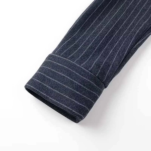 Gros plan détaillé montrant les fines rayures verticales blanches sur la manche du manteau bleu