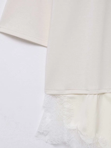 Détail d'un haut en maille crème avec bordure en dentelle cil élégante et texture fine