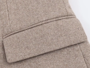 Detailed macro view of herringbone pattern wool fabric with pocket on brown blazer