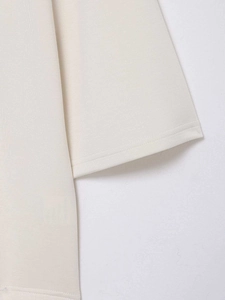 Gros plan détaillé des coutures et de la texture du tissu sur ce haut en dentelle blanc