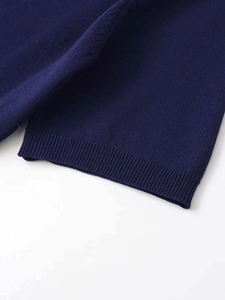 Gros plan détaillé du tricot bleu marine avec ourlet côtelé et texture de qualité