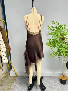 Détail d'une robe en satin marron foncé avec dentelle délicate et ourlet asymétrique