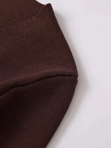 Gros plan sur la texture du tricot marron foncé et les coutures de haute qualité