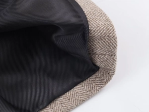 Macro shot of brown herringbone wool fabric with black pinstripe satin lining detail