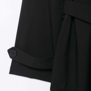 Detailansicht der schwarzen zweireihigen Trenchcoat-Manschette und Twill-Stoffstruktur