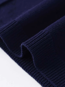 Détail de la maille fine bleu marine avec bords côtelés et texture douce et lisse