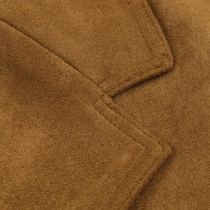 Dettaglio macro del tessuto scamosciato color caramello con cuciture rinforzate tono su tono