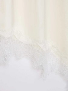 Détail rapproché de tissu crème avec bordure délicate en dentelle de cils blanche