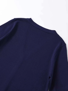 Gros plan sur la maille fine et les détails de couture d'un haut bleu marine à col en V