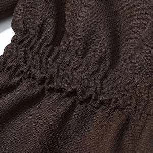 Detail of dark brown textured fabric featuring elasticated vertical pleats and shirring