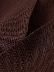 Détail d'un tricot marron foncé haute densité montrant la texture et les coutures de qualité