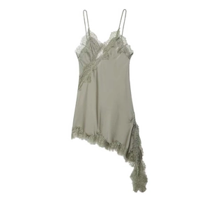 Detail of sage green satin dress featuring intricate lace trim and asymmetric fringe hem