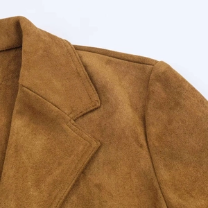 Dettaglio del cappotto in pelle scamosciata marrone con cuciture e trama del bavero
