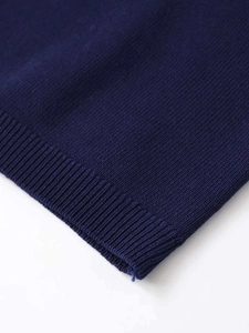 Vue macro de la maille bleu marine montrant la texture côtelée et les coutures détaillées