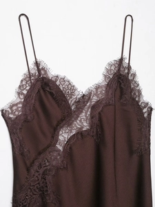 Détail d'une robe en satin marron foncé avec bordure en dentelle cil et décolleté en V