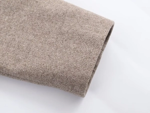 Close-up of classic brown herringbone tweed fabric texture on suit blazer sleeve