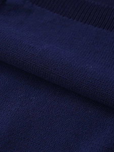 Détail macro du tissu en maille bleu marine montrant la texture du jersey et le bord côtelé
