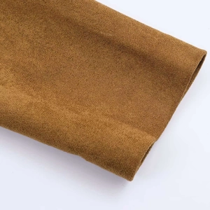 Primo piano del polsino di un cappotto scamosciato marrone con cuciture fini