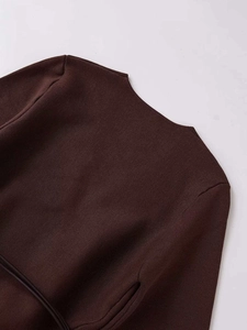 Détail de maille marron foncé montrant la texture d'épaule et la ceinture nouée