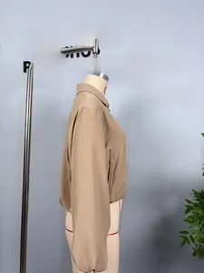 Detail view of the khaki zip-up jacket featuring a stand collar and elastic cuffs on mannequin