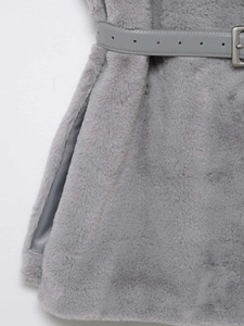 Dettaglio del gilet in ecopelliccia grigia con cintura in pelle e fibbia argento