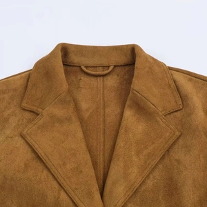 Dettaglio del colletto del cappotto in finta pelle scamosciata marrone e trama del tessuto