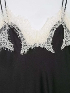 Détail d'un caraco en soie noire avec bordure délicate en dentelle de cils ivoire