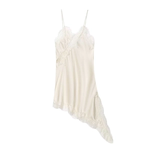 Detailed view of white silk satin slip dress featuring intricate lace trim and asymmetrical hem