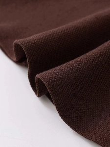 Détail macro de la texture du tricot marron foncé de qualité avec tissage piqué fin