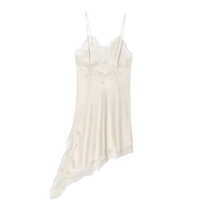 Detail of cream silk slip dress featuring delicate white lace trim and asymmetrical hemline