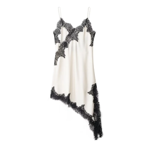 Détail de la robe nuisette en satin blanc avec dentelle noire et ourlet asymétrique élégant