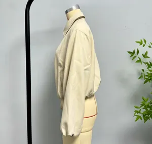Close-up of cream stand-collar jacket with dropped shoulders and side pockets