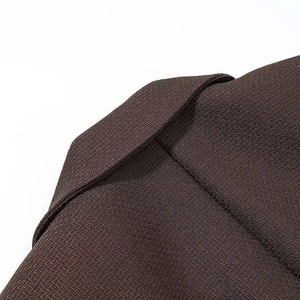 Close-up of brown blazer collar showing high-quality twill fabric and neat stitching