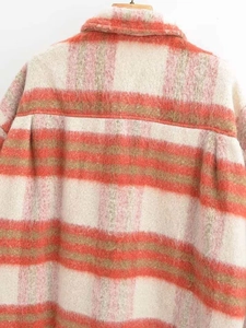 Dettaglio del retro di una giacca a camicia lunga a quadri in peluche arancione