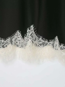 Gros plan d'un haut en soie noire avec bordure en dentelle de cils blanche raffinée