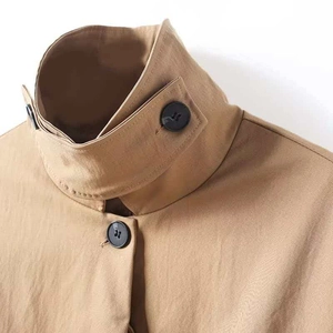 Detailansicht des khakifarbenen Parkas mit Stehkragen und schwarzem Harzknopf-Design