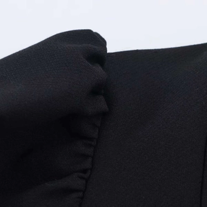 Vue détaillée du tissu noir avec texture plissée sur une mini robe d'été élégante