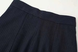 Macro shot of waistband tailoring on dark blue pinstripe wide leg trousers fabric