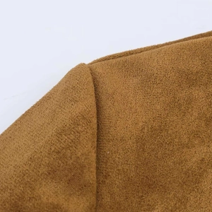Dettaglio della cucitura della spalla su un cappotto minimalista in camoscio marrone