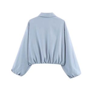 Rear view of light blue short jacket with dropped shoulders and elastic hem details
