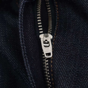 Gros plan d'une robe en jean bleu foncé vintage avec fermeture éclair en métal et ceinture