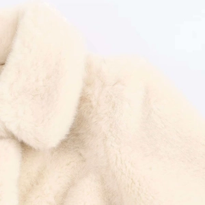 Close-up of white faux fur coat lapel detail with soft plush texture and high luster
